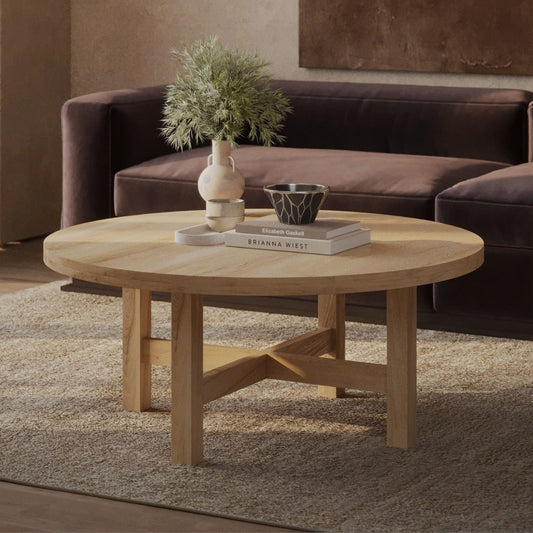 Cozy living room with a round wooden coffee table on a beige rug. 