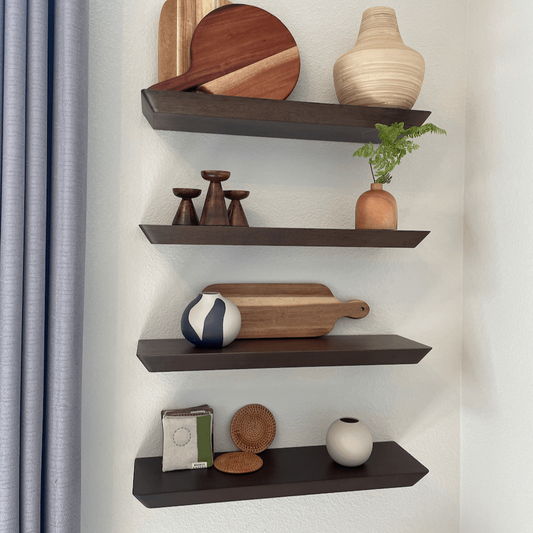 slim edge floating shelves hung on white walls with small home decors on the shelves.